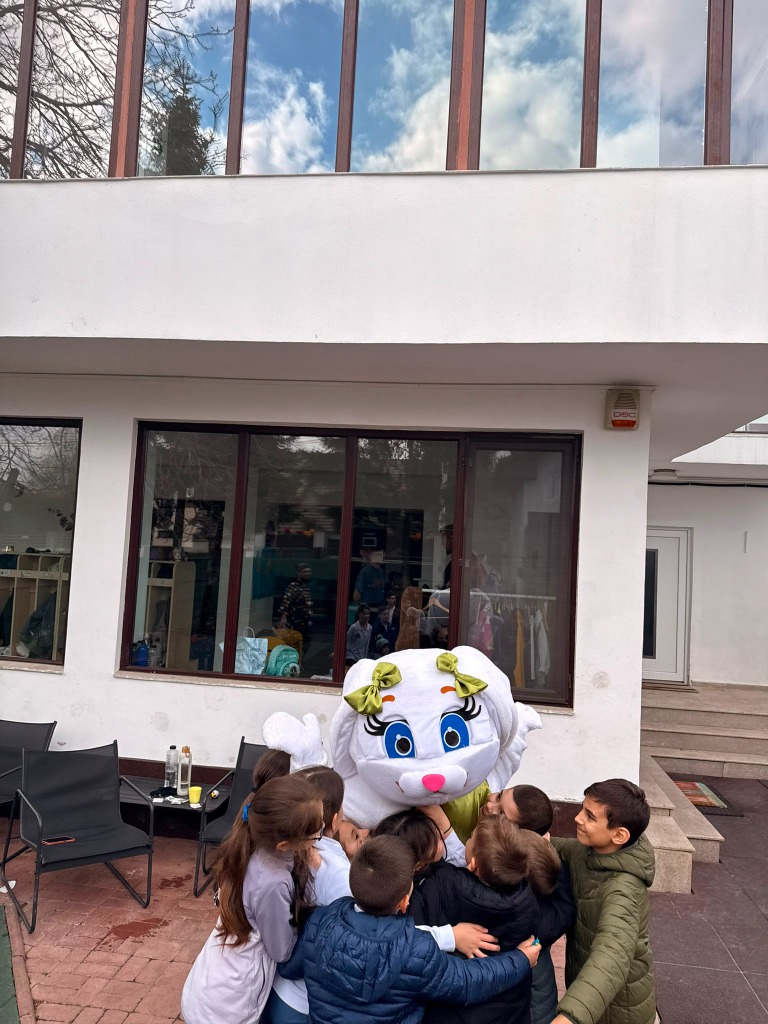 Mascotă iepuraș îmbrățișând copii la petrecere